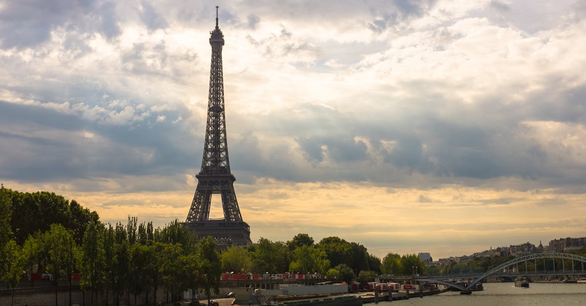 Stunning view of the Eiffel Tower at sunset with the River Seine and lush green trees.