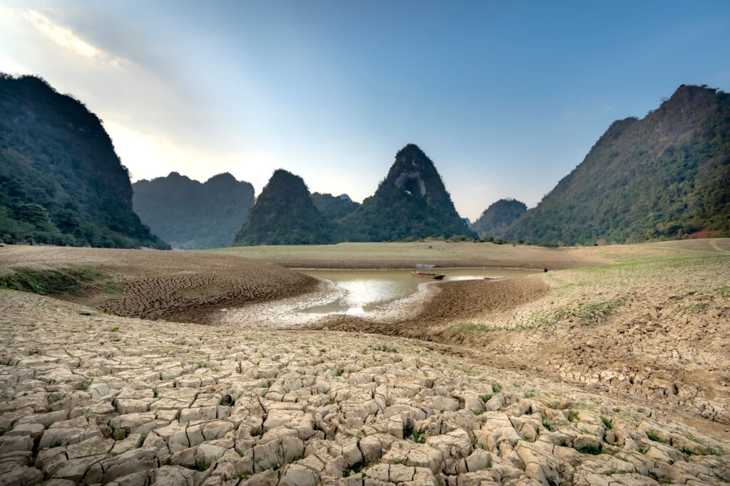 A vivid scene depicting cracked earth surrounded by striking mountains under a clear sky.