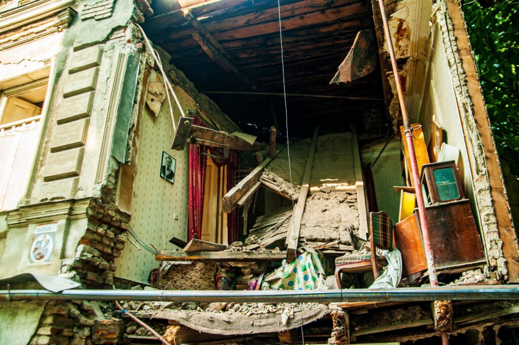 Exterior view of a damaged building with the interior exposed, showcasing severe structural collapse.
